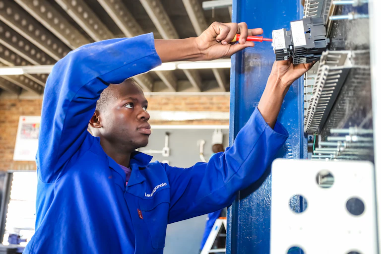 Male student uses screwdriver.