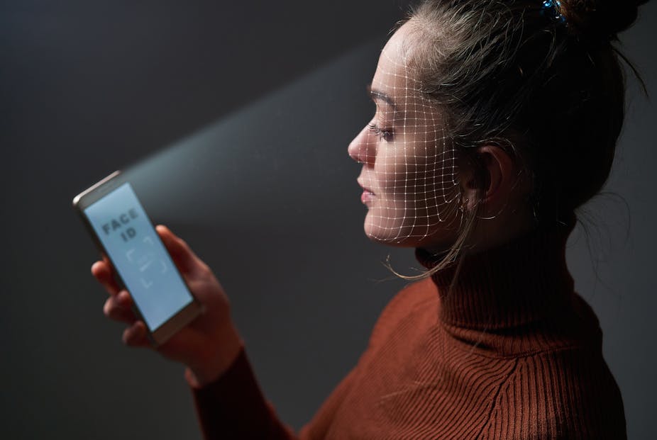 Femme scannant son visage grâce à son téléphone.
