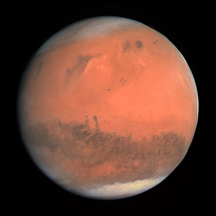 Red planet Mars in space with polar ice caps visible