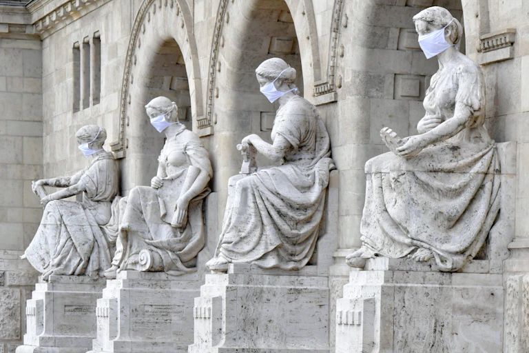 Statues in Budapest adorned with face masks.