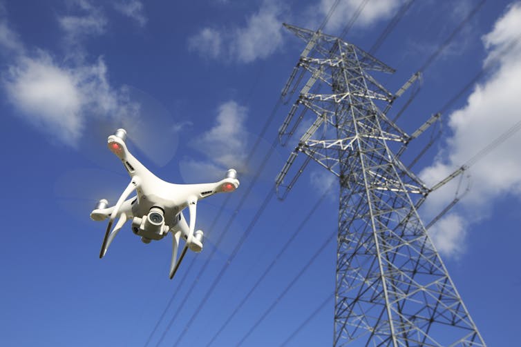 Drone hovers near electricity pylon