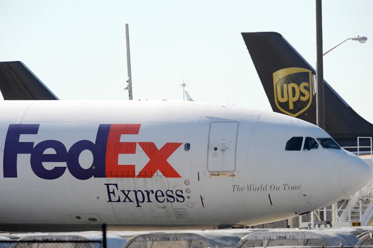 FedEx and UPS planes sitting at an airport.