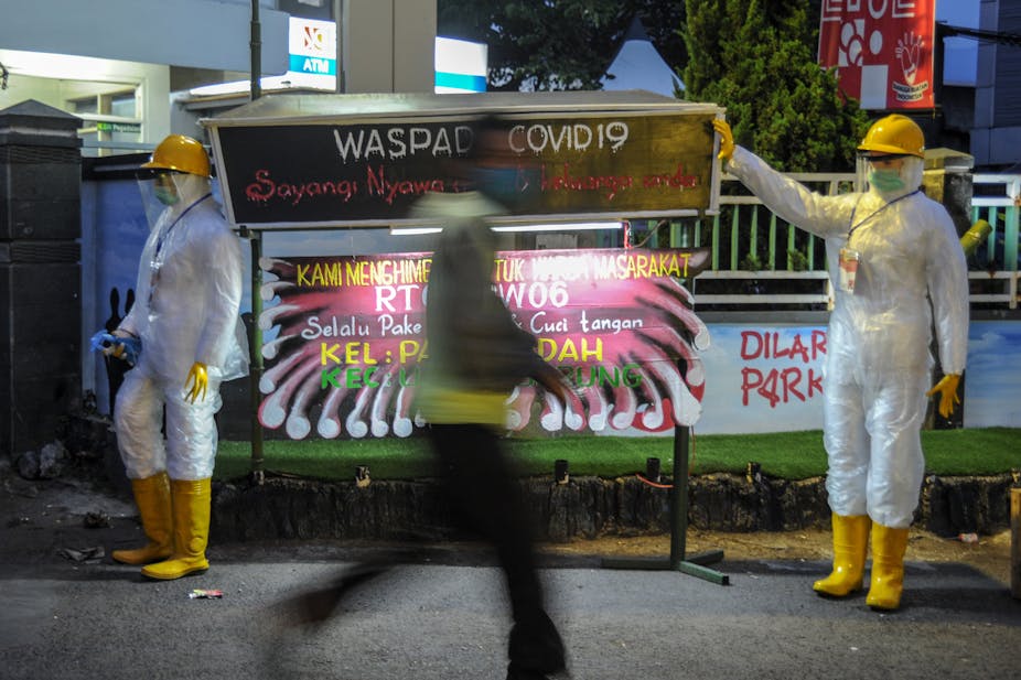Warga melintas di samping patung himbauan waspada COVID-19 di Sukup Baru, Ujung Berung, Bandung, Jawa Barat, Rabu (16/9/2020)