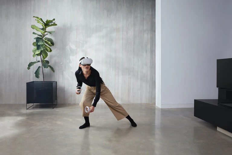 A woman wears a virtual reality headset in a minimalist office setting.