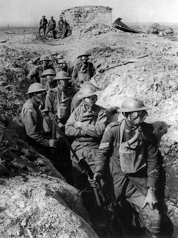 Foto en blanco y negro de soldados en una trinchera durante la primera guerra mundial con máscaras antigás.