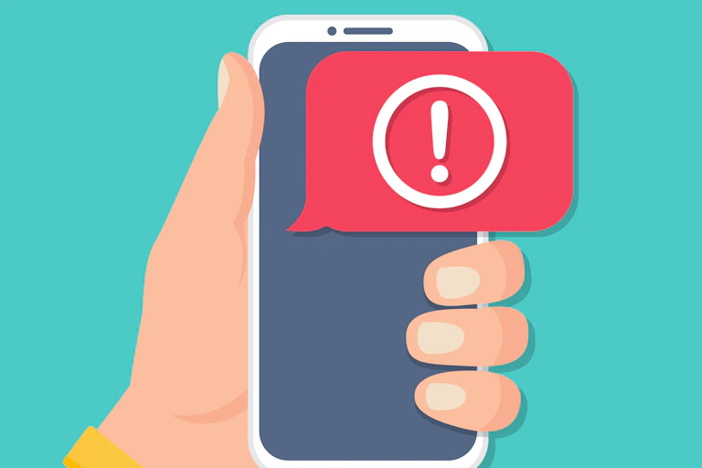 A hand holding a phone with an alert.