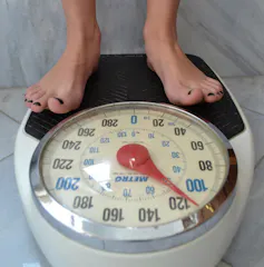 A woman's feet standing on a scale that reads about 51 kilograms.