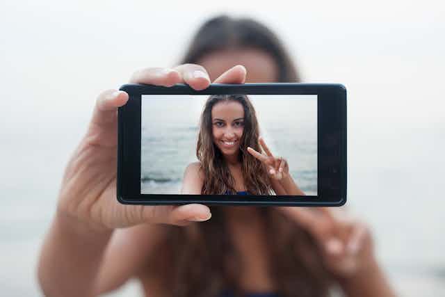 Rostro de una chica en un teléfono móvil mientras se hace una foto a sí misma.