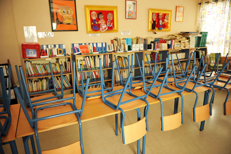 Aula con las sillas sobre las mesas.