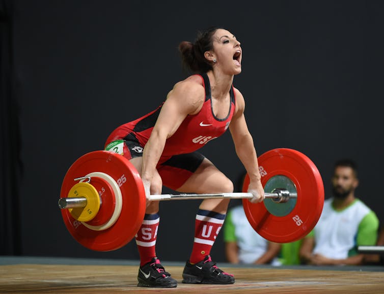 Female olympic weightlifter performing a deadlift.