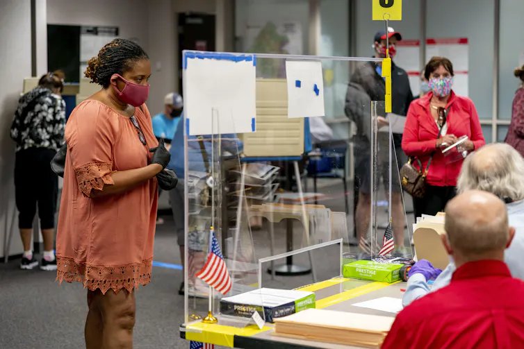 A woman waits to receive her ballot.