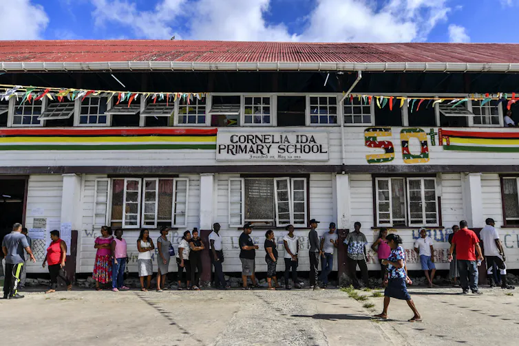 Line of people standing outside a colorfully painted school