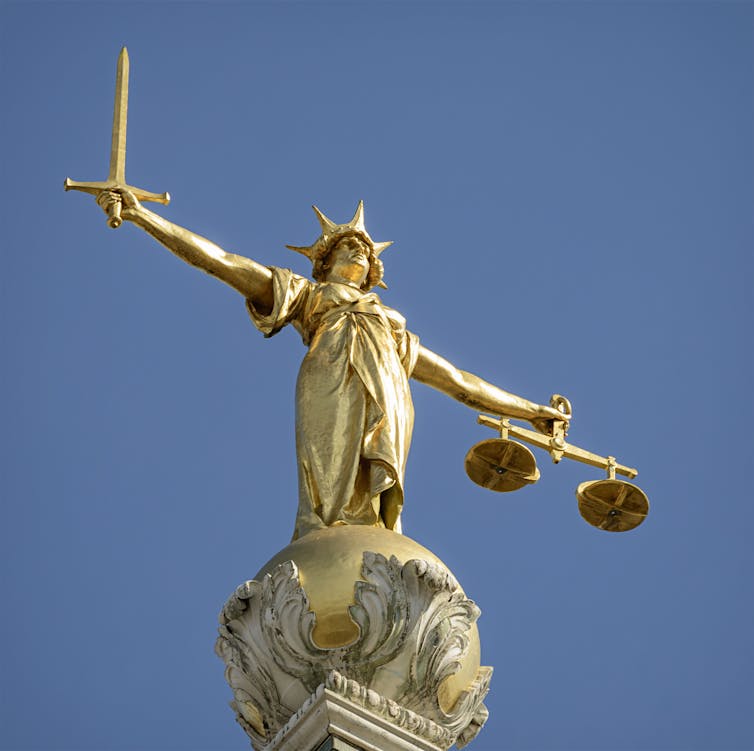 A statue of Lady Justice with a sword in one hand and scales in the other.