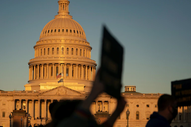 Image of the capitol with protesters in front