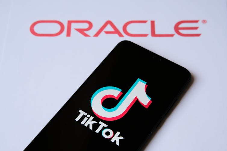 A phone sits against the Oracle brand logo.