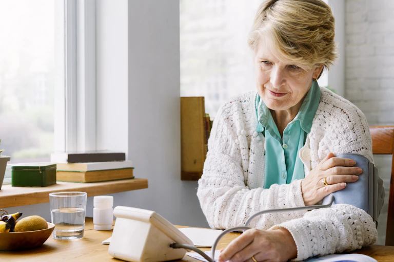 A woman taking her blood pressure using an electronic device