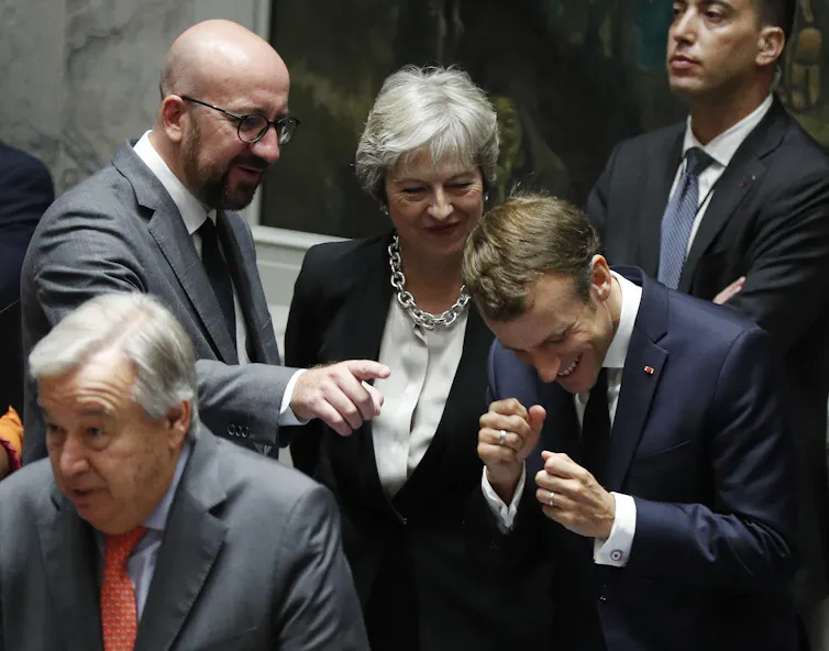 Charles Michel, Theresa May and Emmanuel Macron laughing together.
