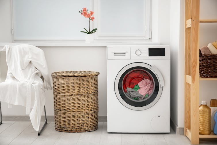 Washing machine next to laundry basket.