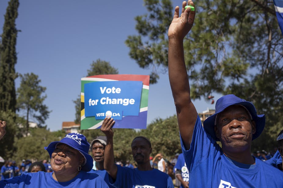 A man carries a placard in colours of the Democratic Allianc's blue colours  with the words: Vote for change. Vote DA at a march