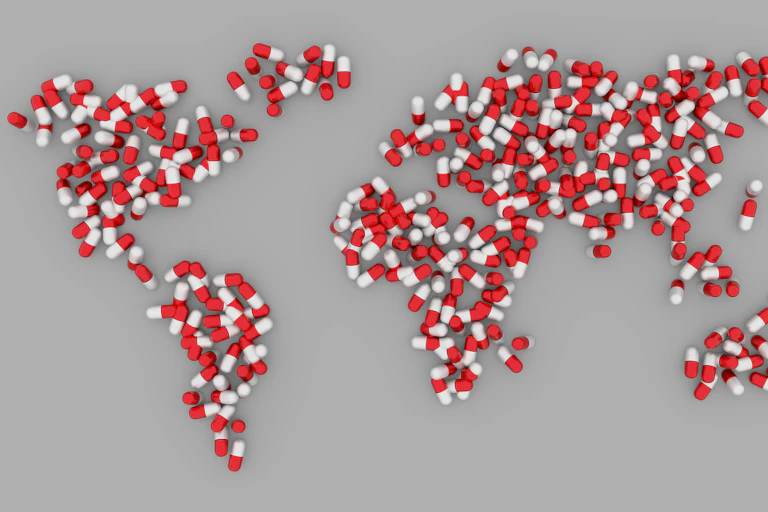 Red and white drug capsules arranged in the shape of the continents to form a map of the world.