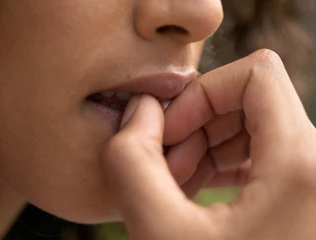 closeup of woman biting fingers