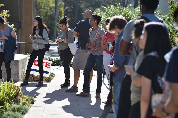 Students wait to vote at a polling station on the campus of the University of California, Irvine