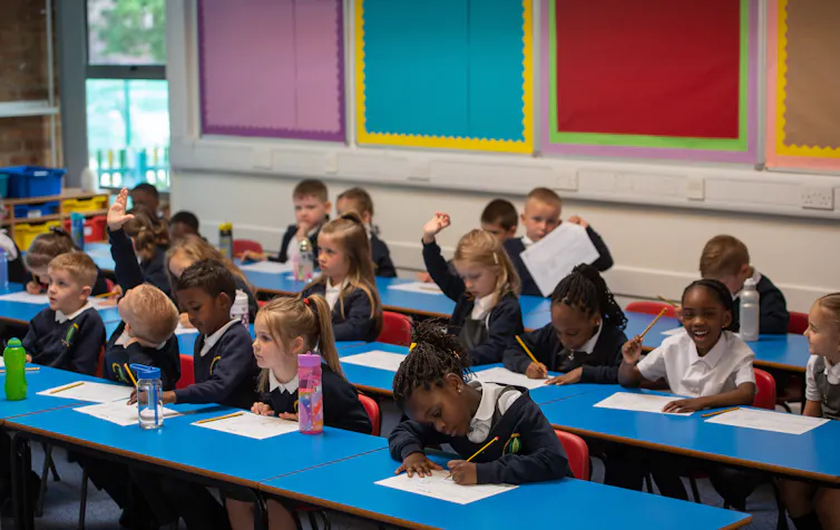 School children do classwork in a classroom.