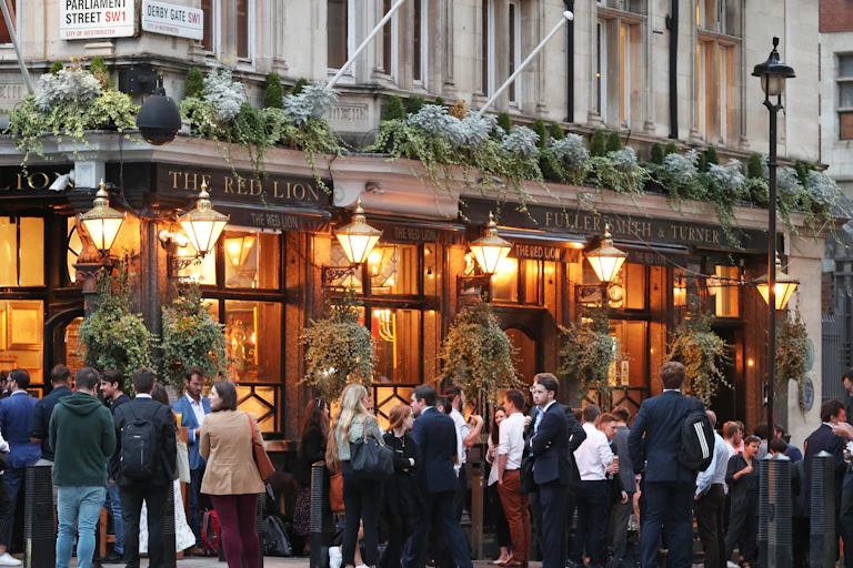 People gather on the street outside a pub