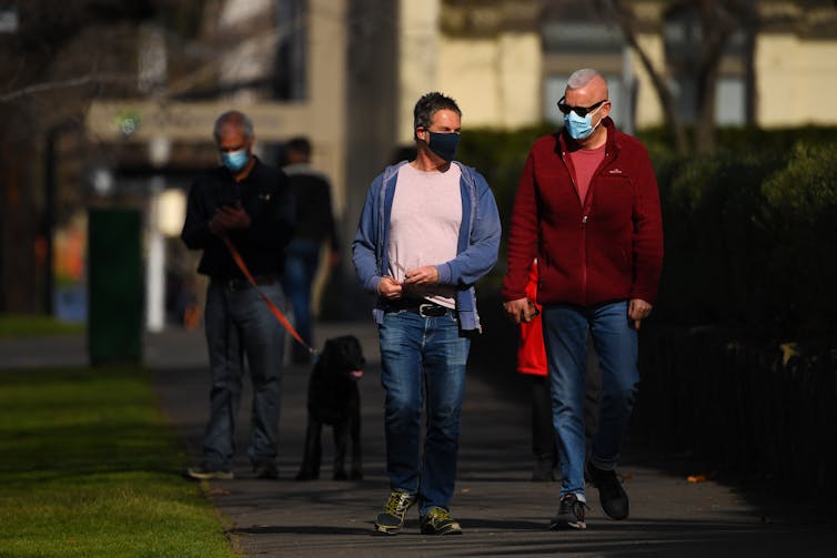 People walking through a Melbourne street wearing masks.