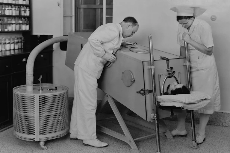 Polio patient in an iron lung to help them breathe.