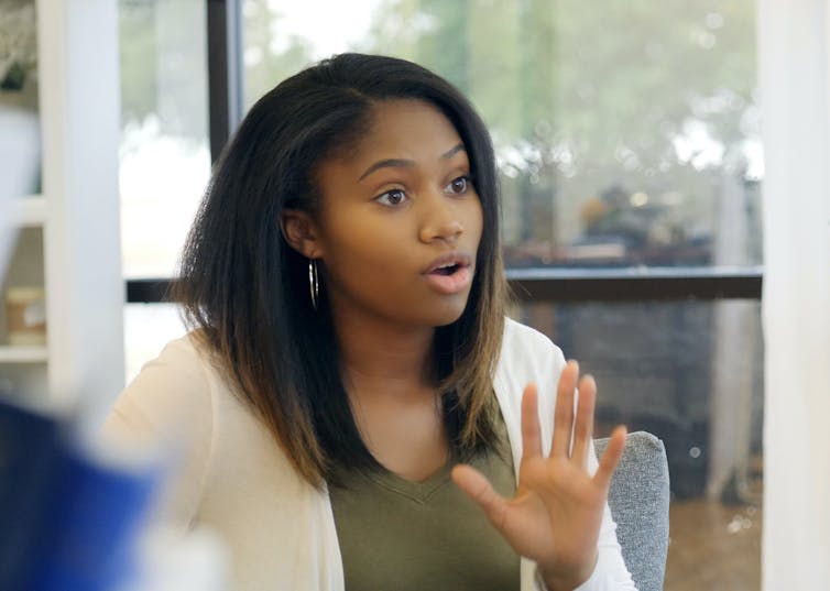 young Black woman with her hand up