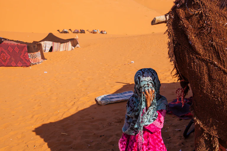 A girl child covering her face with her hand.