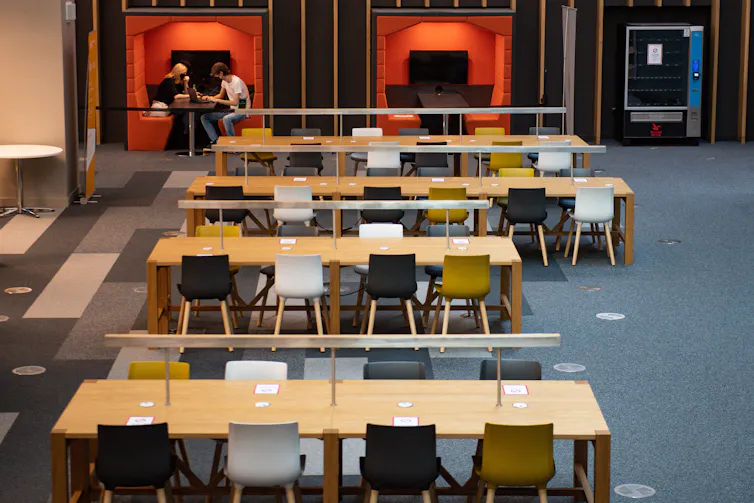 Four empty desks in a university library.