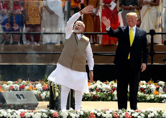 Indian Prime Minister Narendra Modi and U.S. President Donald Trump wave to a crowd.