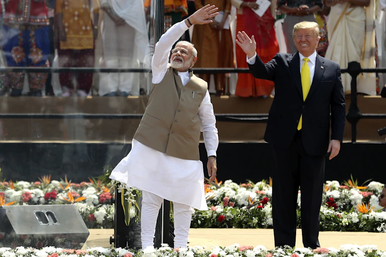 Indian Prime Minister Narendra Modi and U.S. President Donald Trump wave to a crowd.