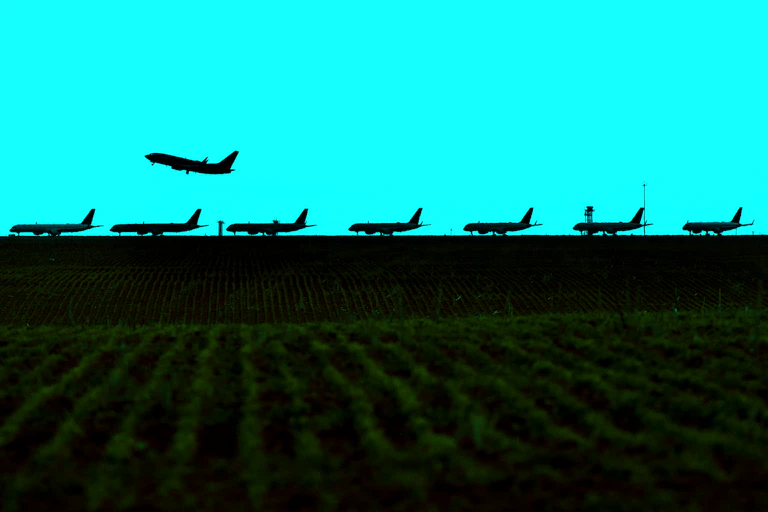 Photo illustration of an airplane taking off over a line of parked aircraft in April 2020.