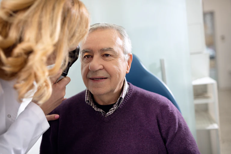 Older man has his vision tested by a female doctor.