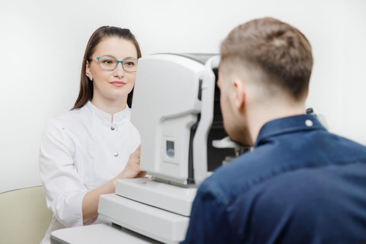 Man has his eyes tested using an OCT machine.