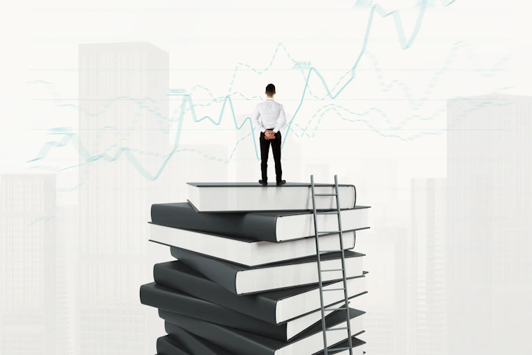Un hombre de negocios sobre una pila de libros observa curvas de negocio ascendentes.