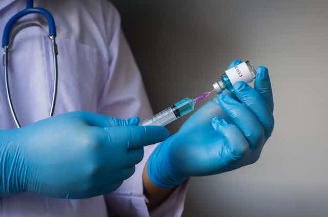 Medic prepares to inject a coronavirus vaccine