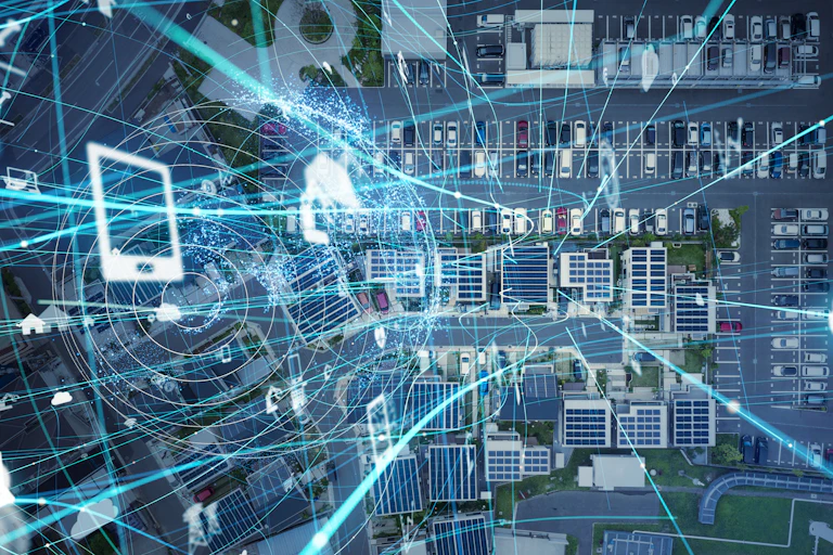 A graphic of devices and connections overlaid on a birds-eye view of a building cluster surrounded by parking