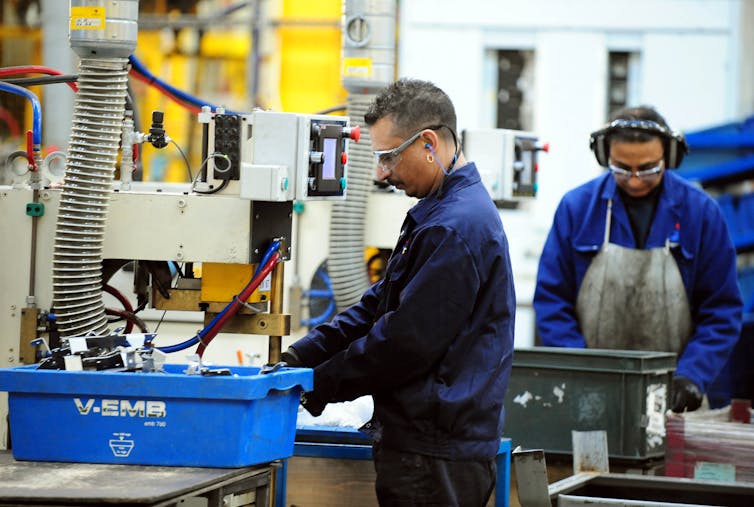 Two men working on a factory line.