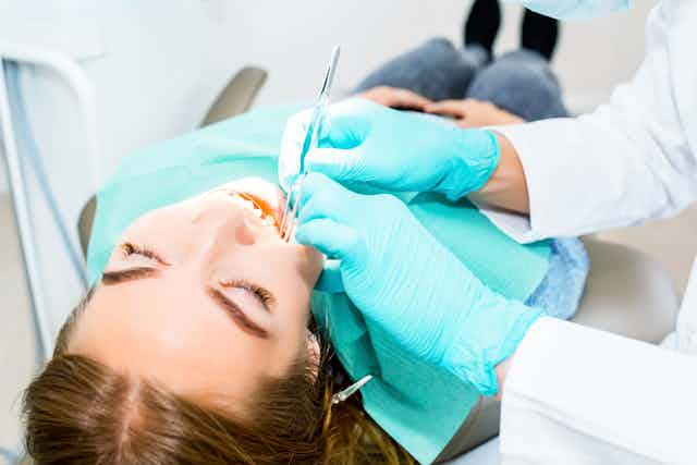 Young woman lying on a dentist chair having a dental check up