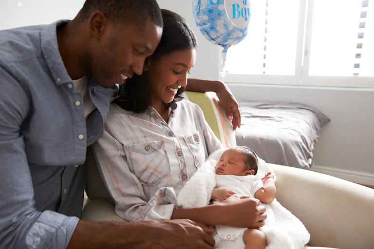 Two parents holding their newborn baby.