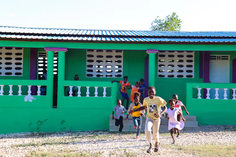 Students laugh outside a school.