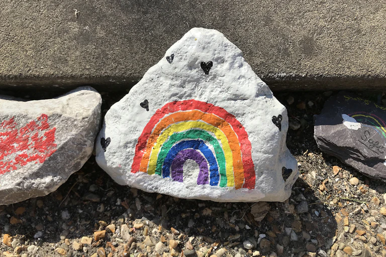 Stone with a rainbow painted on it.