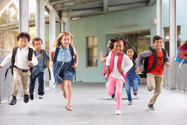 Primary school kids running in school.