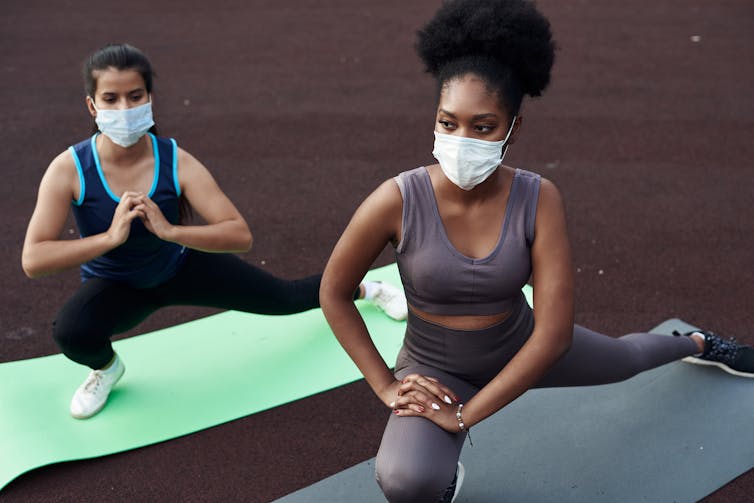 Women doing yoga wearing masks