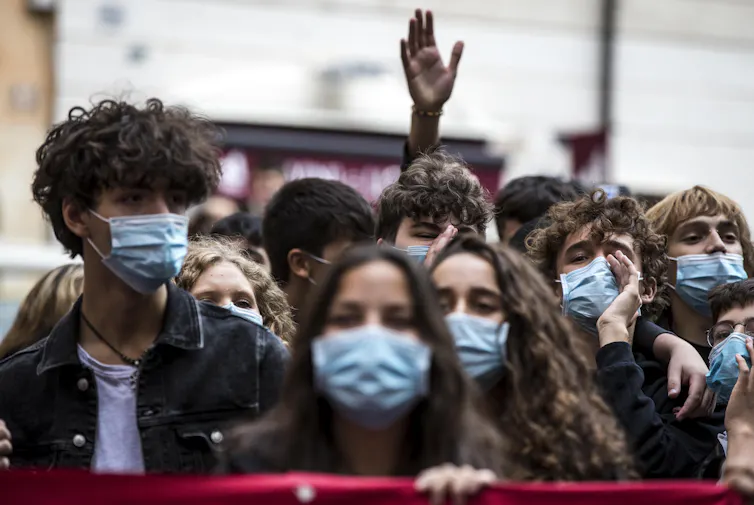 Students wearing facemasks attend a protest.