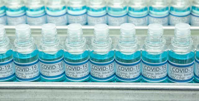 Línea de producción de vacunas. Frascos con la etiqueta COVID-19